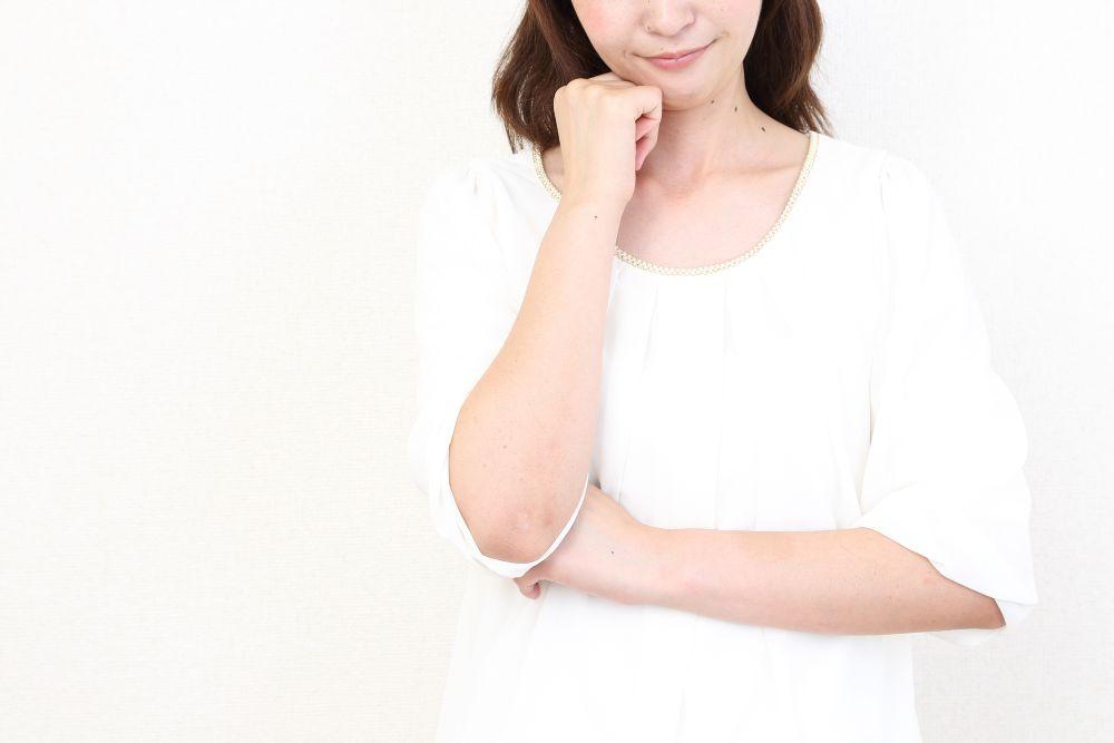 腕を組んで考える女性