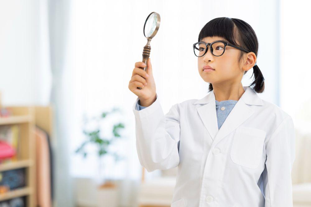 虫眼鏡を除く白衣を着た少女